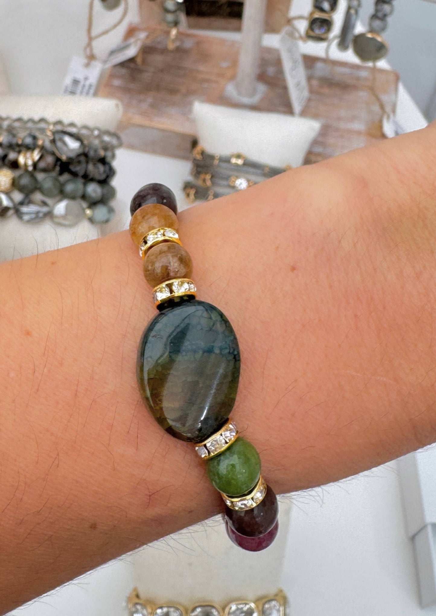 Multicolored beaded bracelet on a wrist with a blurred jewelry store background