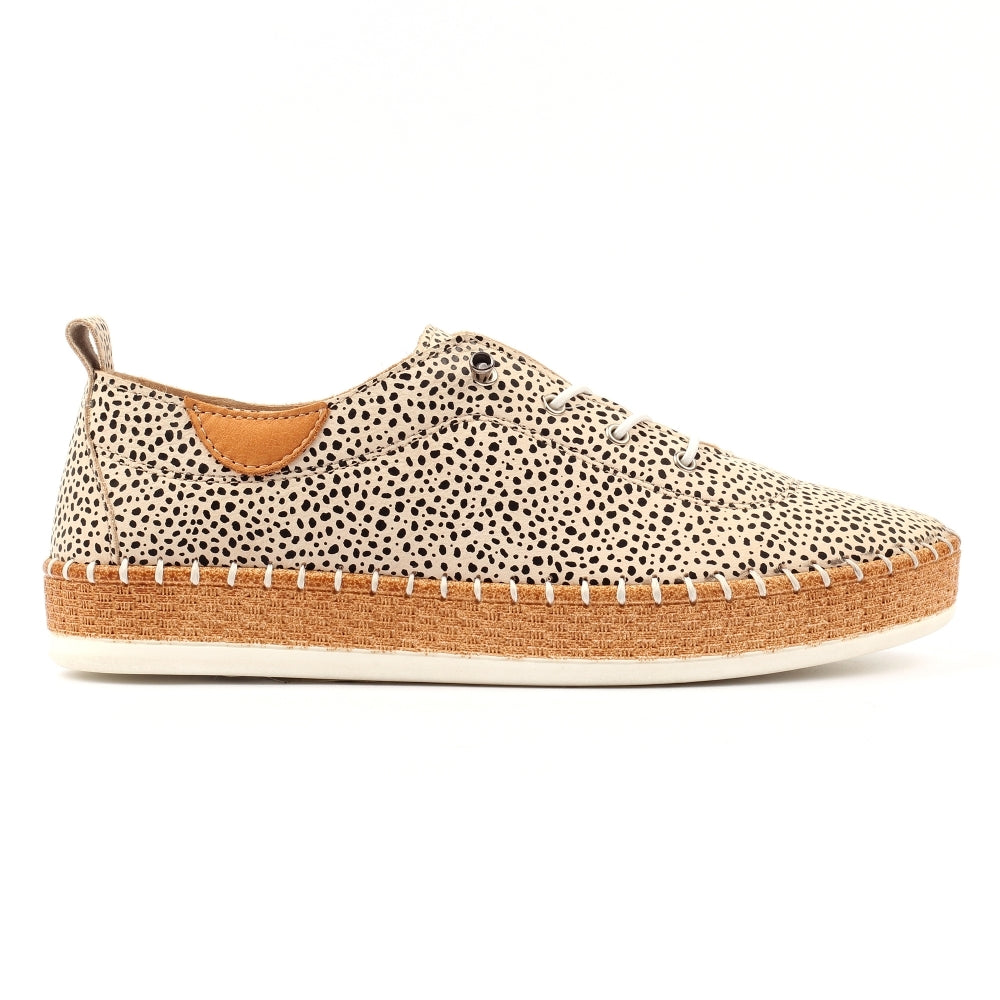 Sneaker with spotted pattern and brown sole on a white background