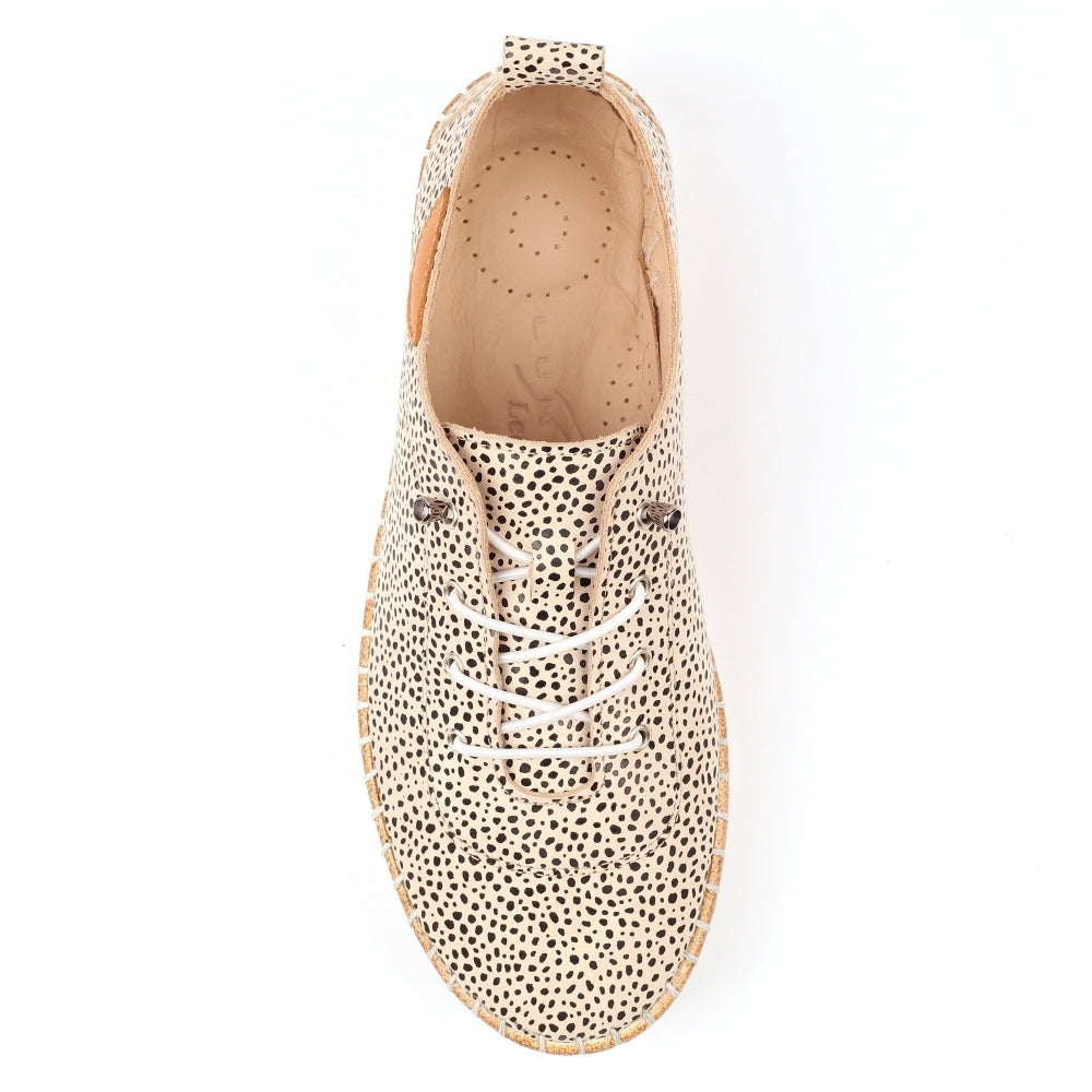 Beige shoe with black polka dot pattern on a white background