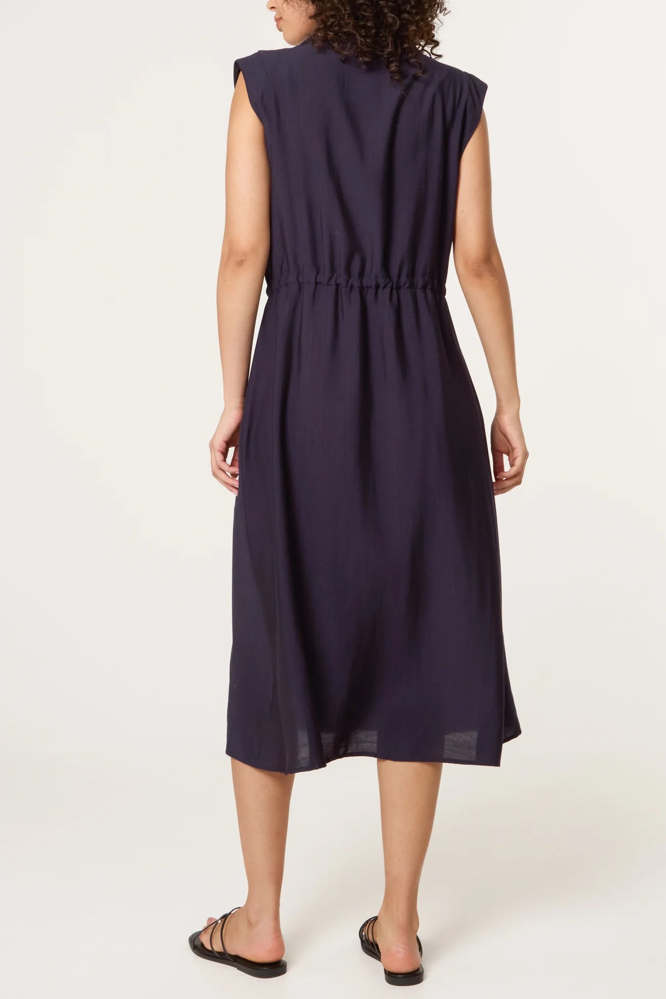 Woman wearing a navy blue dress on a white background